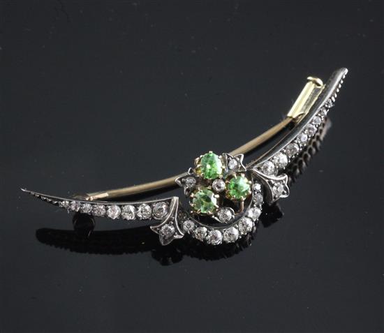 A late Victorian, gold and silver, diamond and demantoid garnet set shaped crescent brooch, 49mm.